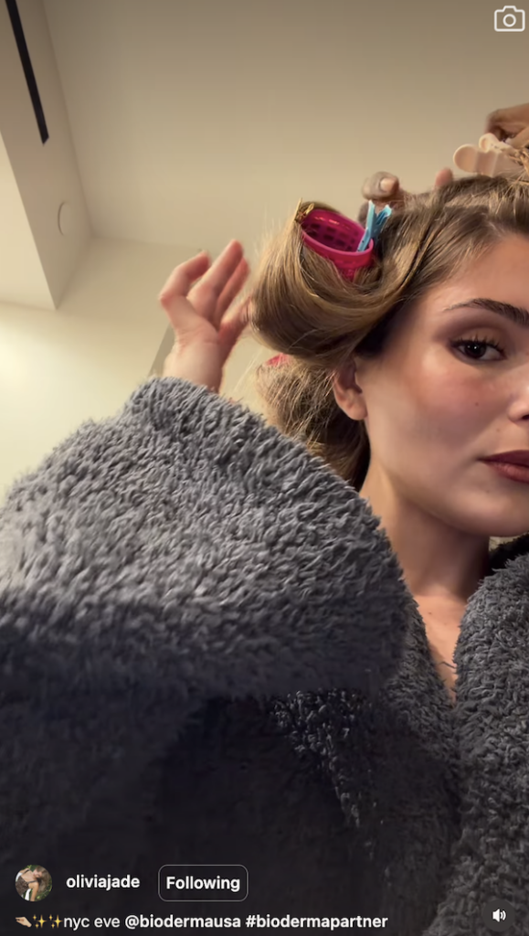 Olivia Jade getting ready with large velcro rollers while wearing a gray robe